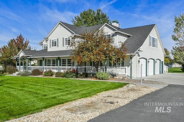 view of front of house featuring a garage, a front yard, covered porch, and driveway