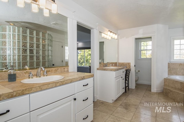 bathroom featuring a sink, a textured ceiling, and toilet