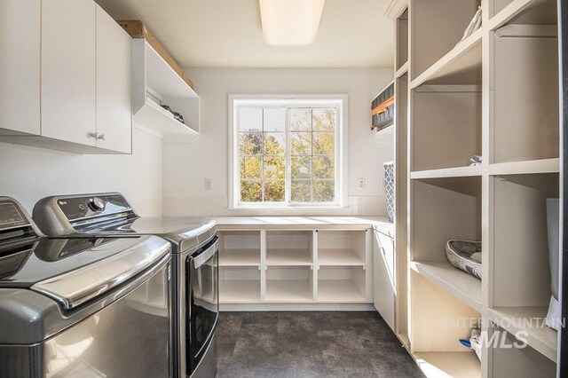 clothes washing area featuring cabinet space and washing machine and clothes dryer