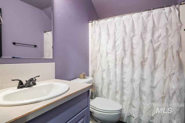 full bathroom with a textured wall, toilet, backsplash, and vanity