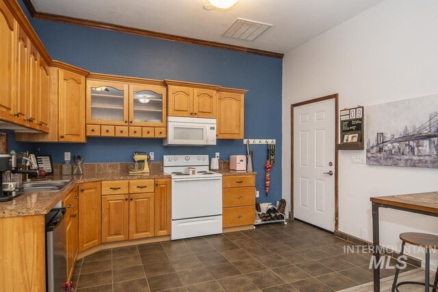 kitchen featuring white appliances, a sink, visible vents, brown cabinetry, and glass insert cabinets