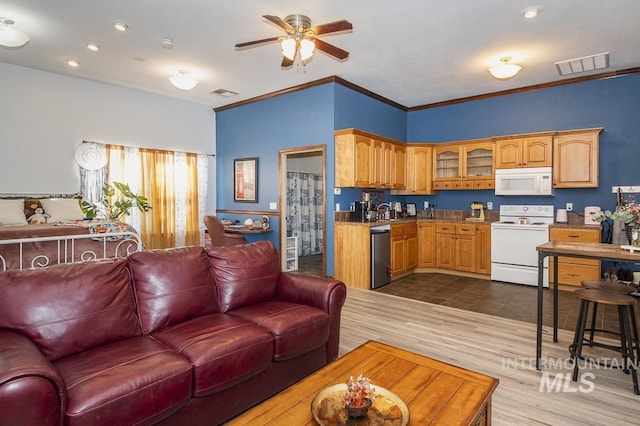 kitchen featuring light countertops, white appliances, visible vents, and crown molding