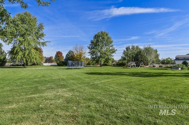 view of yard with playground community and a trampoline