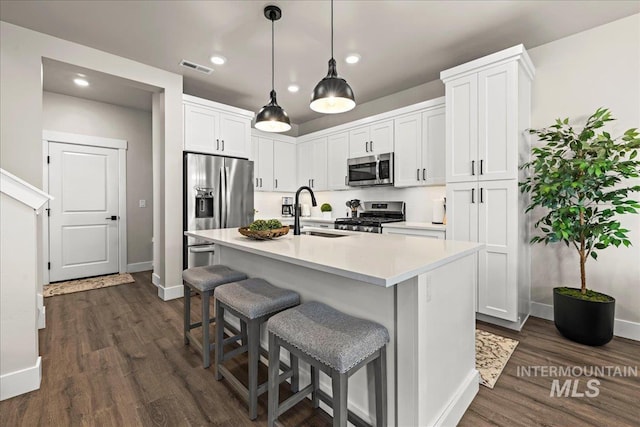 205 S Ripplerock Ln, Star, ID 83669 - kitchen featuring a sink, stainless steel appliances, baseboards, dark wood-type flooring, and light countertops