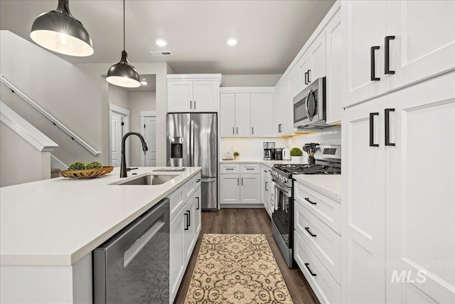 205 S Ripplerock Ln, Star, ID 83669 - kitchen featuring stainless steel appliances, a sink, dark wood finished floors, light countertops, and white cabinets