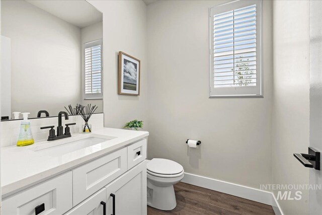 205 S Ripplerock Ln, Star, ID 83669 - half bathroom with wood finished floors, toilet, baseboards, vanity, and tasteful backsplash