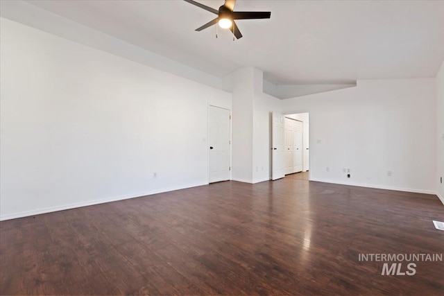 empty room with vaulted ceiling, ceiling fan, and dark wood-type flooring