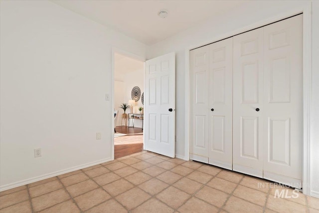 unfurnished bedroom featuring a closet and light tile patterned flooring