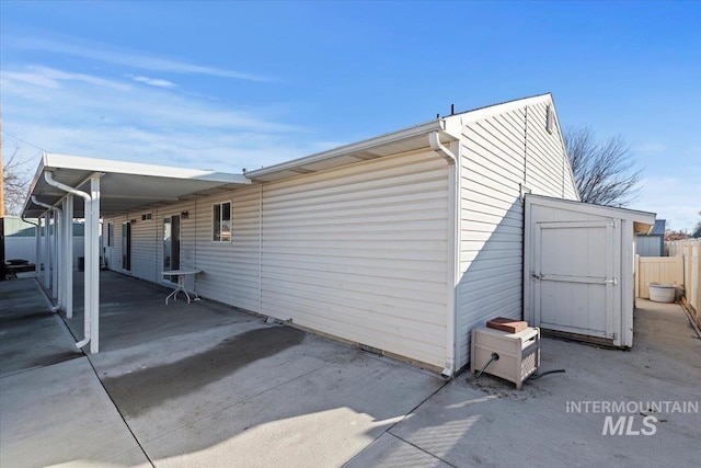 view of property exterior with a patio area and a shed