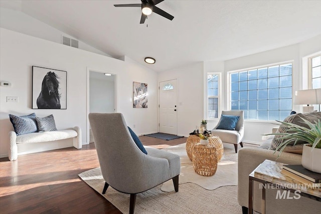 living room with hardwood / wood-style flooring, vaulted ceiling, and ceiling fan