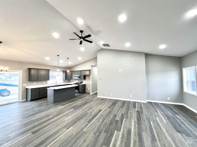 kitchen featuring appliances with stainless steel finishes, dark hardwood / wood-style floors, decorative light fixtures, gray cabinetry, and a center island