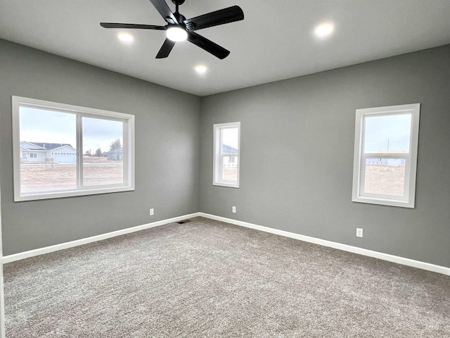 spare room featuring ceiling fan, carpet floors, and a healthy amount of sunlight