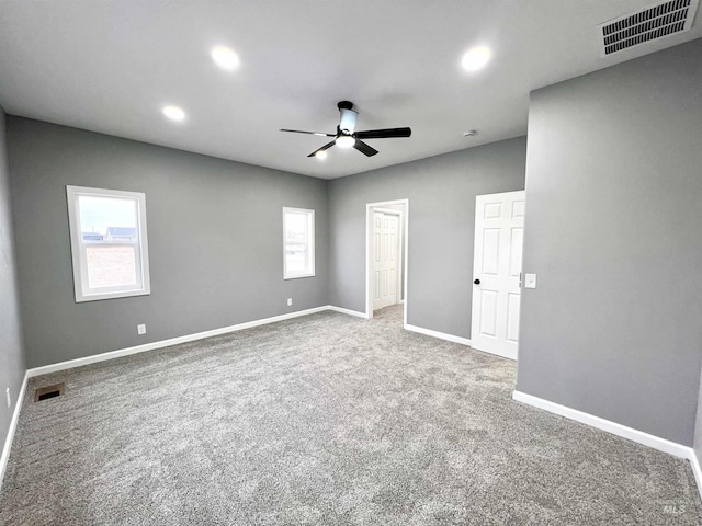 carpeted spare room featuring ceiling fan