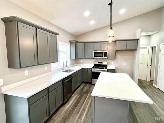 kitchen with a kitchen island, appliances with stainless steel finishes, sink, gray cabinetry, and hanging light fixtures