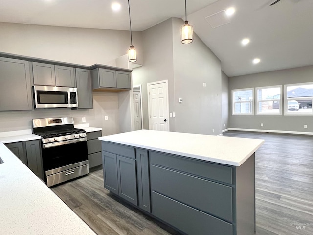 kitchen with gray cabinets, appliances with stainless steel finishes, dark hardwood / wood-style floors, pendant lighting, and high vaulted ceiling