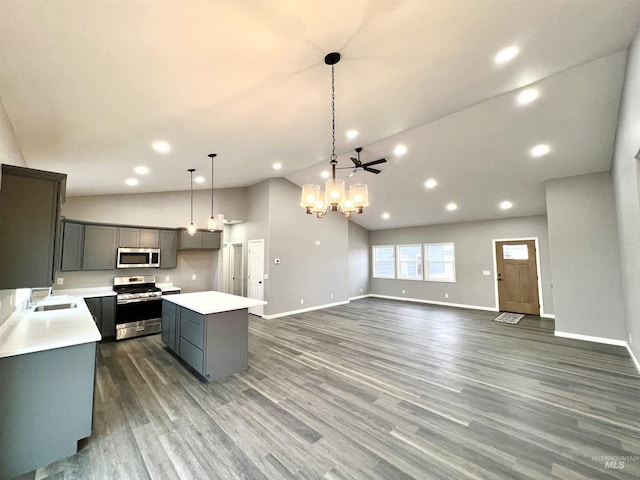 kitchen with stainless steel appliances, gray cabinets, a center island, and decorative light fixtures