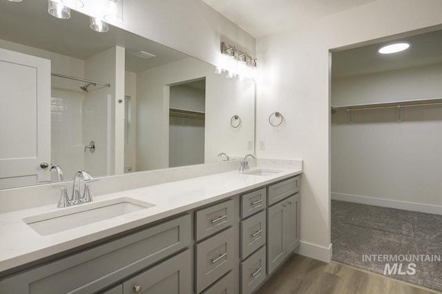 1611 Regency Way, Emmett, ID 83617 - full bathroom with double vanity, a spacious closet, wood finished floors, and a shower