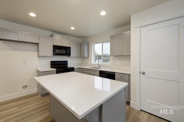 1611 Regency Way, Emmett, ID 83617 - kitchen with black appliances, gray cabinetry, light wood-style flooring, a center island, and recessed lighting