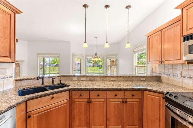 kitchen featuring light stone countertops, a healthy amount of sunlight, stainless steel electric range oven, and a sink