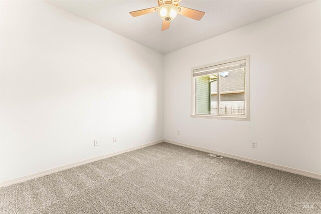 spare room featuring ceiling fan, baseboards, visible vents, and carpet