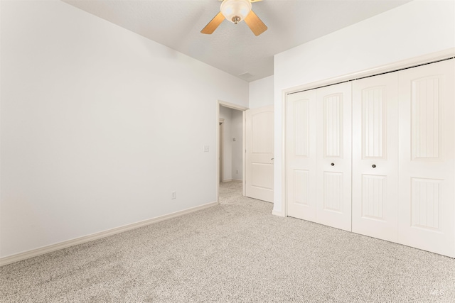 unfurnished bedroom with carpet floors, a closet, baseboards, and ceiling fan