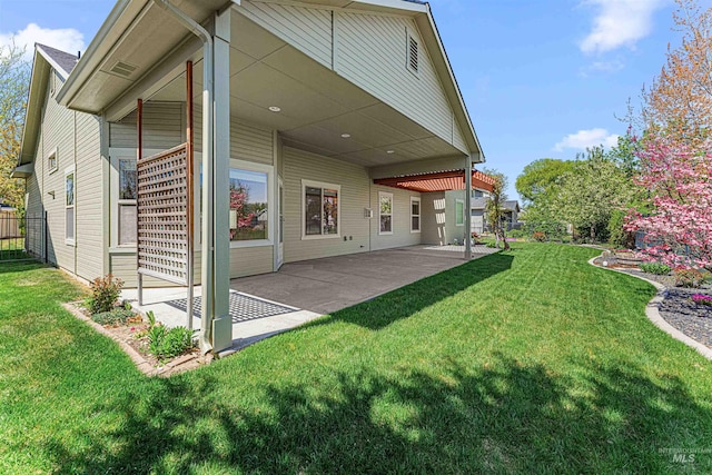 rear view of property featuring a yard and a patio