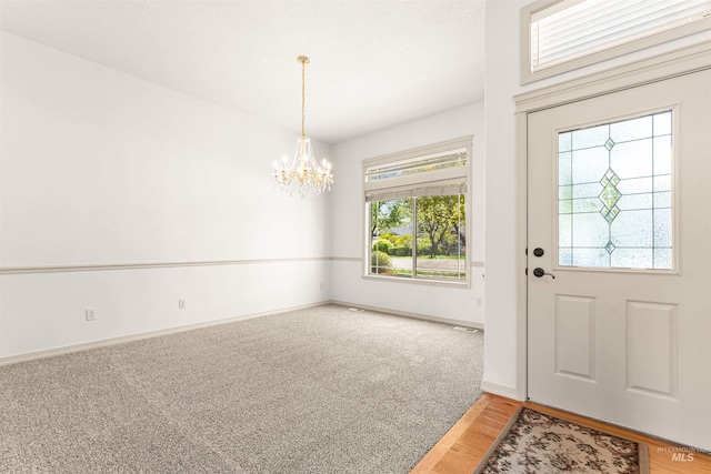 entrance foyer with visible vents, light wood-style flooring, baseboards, and a notable chandelier