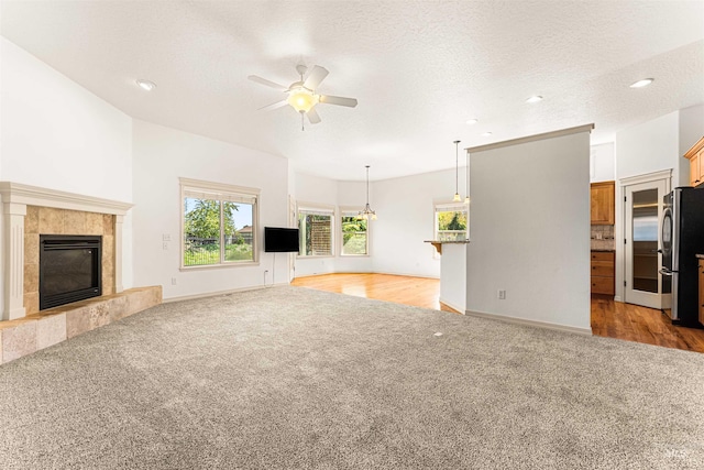 unfurnished living room with a ceiling fan, a fireplace, recessed lighting, and light colored carpet