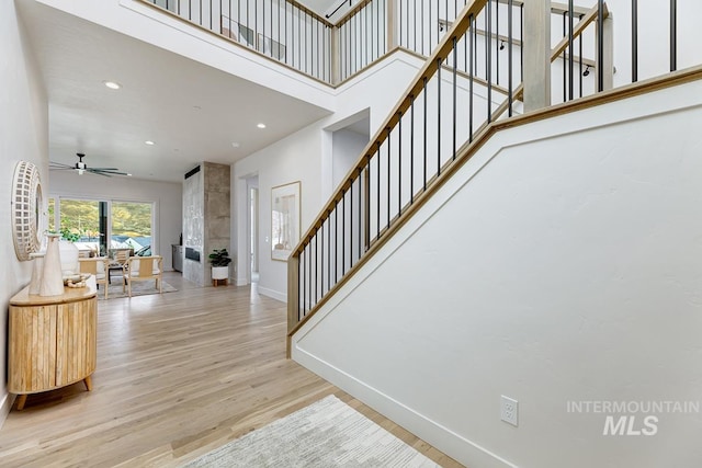 2528 S Linnet Pl, Boise, ID 83716 - stairs featuring baseboards, wood finished floors, ceiling fan, recessed lighting, and a towering ceiling