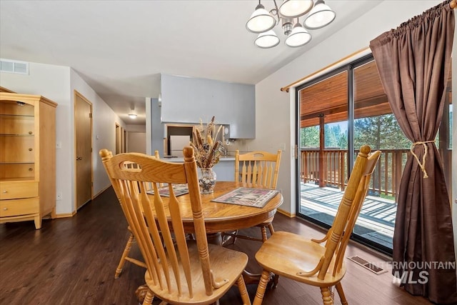 dining space featuring dark wood-type flooring, a chandelier, and visible vents