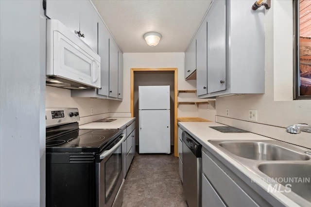 kitchen featuring a sink, appliances with stainless steel finishes, gray cabinetry, and light countertops