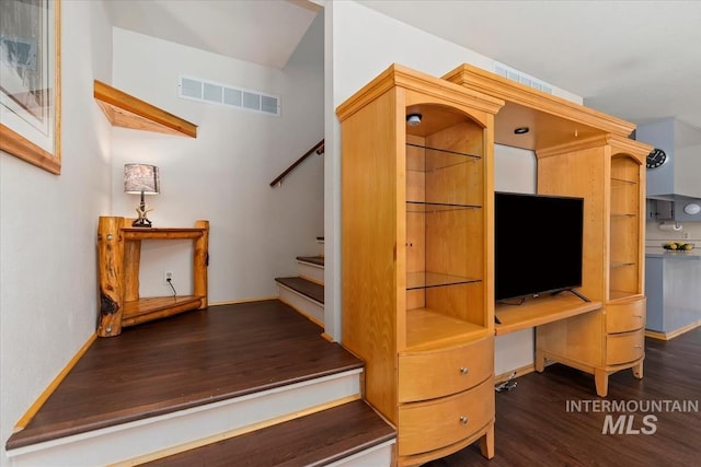 stairs featuring visible vents, baseboards, and wood finished floors