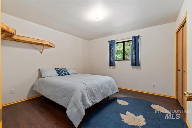 bedroom featuring baseboards and wood finished floors