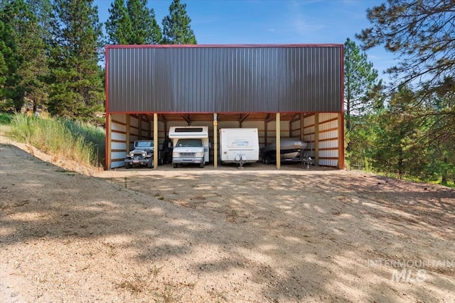 view of parking / parking lot with a detached carport and driveway