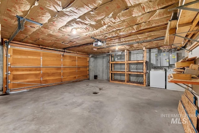 garage featuring independent washer and dryer, a garage door opener, and electric panel