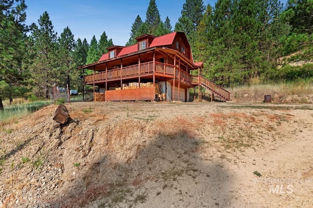 rear view of house with a gambrel roof and a deck