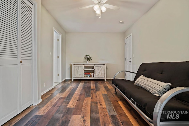 living area with baseboards, ceiling fan, and wood finished floors