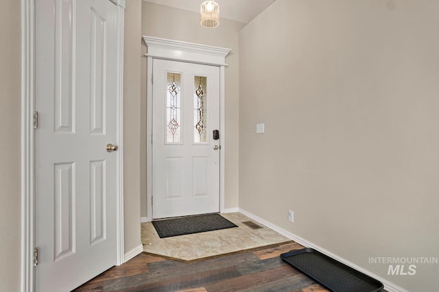 entrance foyer featuring baseboards, visible vents, and wood finished floors