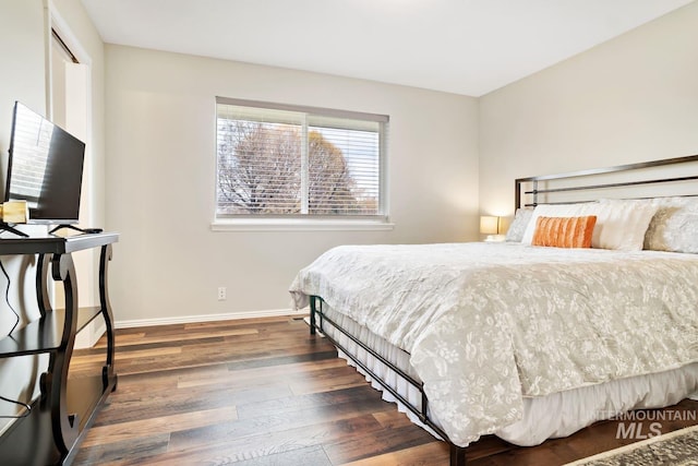 bedroom with wood finished floors and baseboards