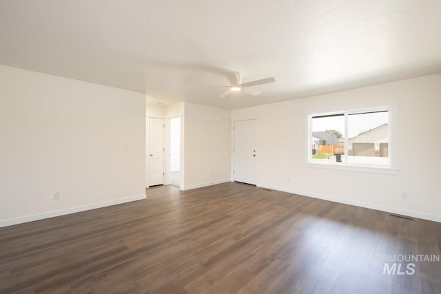 unfurnished room featuring dark wood-type flooring and ceiling fan