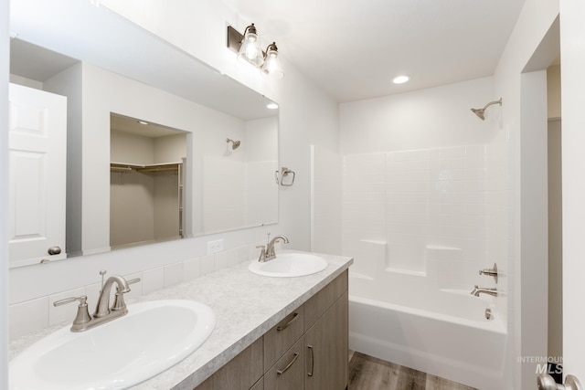 bathroom with tasteful backsplash, vanity, shower / bath combination, and hardwood / wood-style flooring