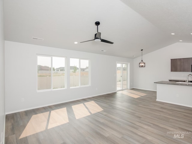 unfurnished living room featuring light wood-type flooring, ceiling fan, lofted ceiling, and sink