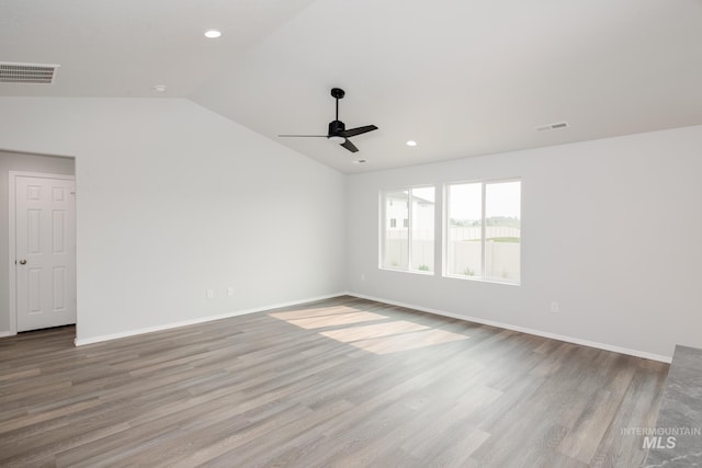 spare room with lofted ceiling, ceiling fan, and light wood-type flooring