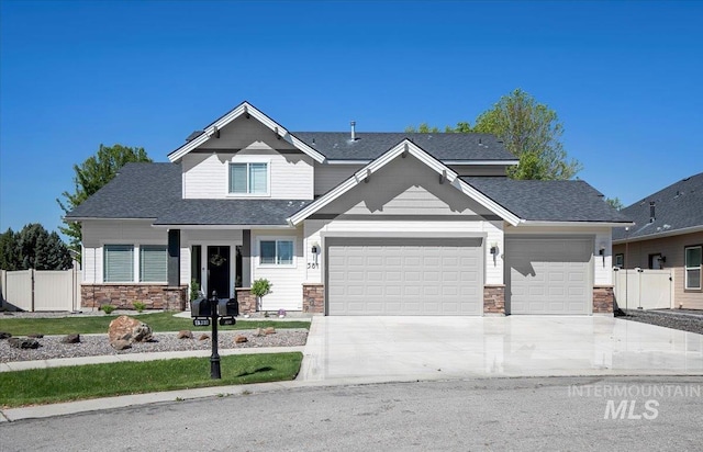 craftsman house featuring fence, a garage, concrete driveway, stone siding, and a shingled roof