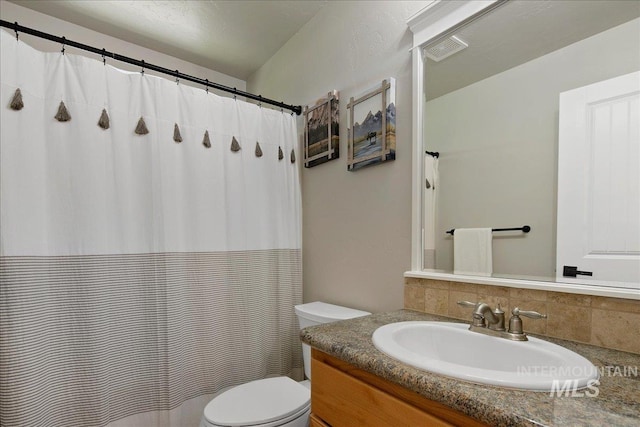 bathroom featuring toilet, backsplash, vanity, and a shower with shower curtain