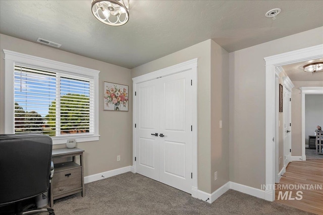 carpeted home office with baseboards and a chandelier