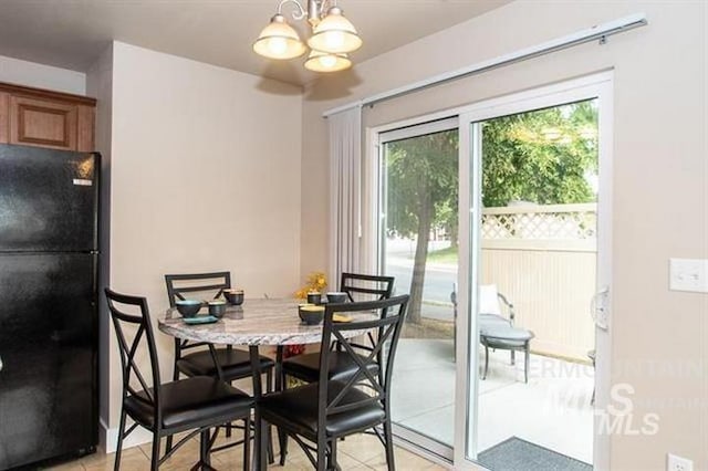 tiled dining room featuring a chandelier