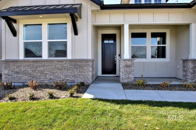 property entrance with a standing seam roof, stone siding, metal roof, and board and batten siding