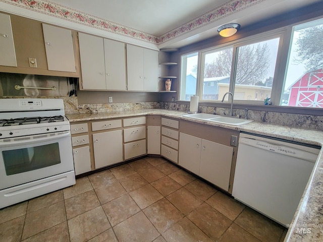 kitchen with light countertops, white appliances, open shelves, and a sink