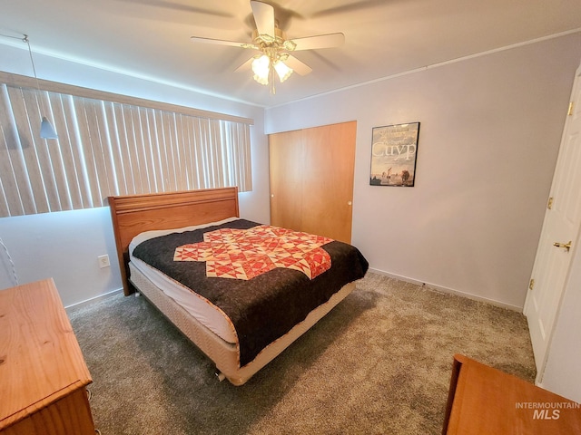 carpeted bedroom featuring a ceiling fan, a closet, and baseboards